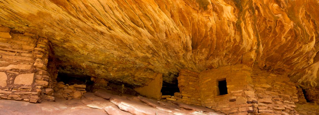Stone dwellings tucked beneath flame-like bands of sandstone in Bears Ears National Monument.
